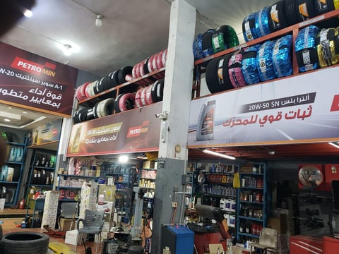 Auto parts store interior with shelves of tires, oil products, and automotive supplies
