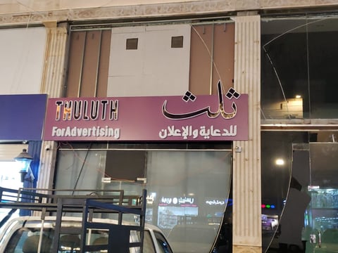 Storefront with purple and pink signage reading Truth For Advertising