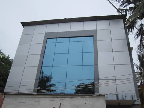 Modern building facade with large blue-tinted glass window panel