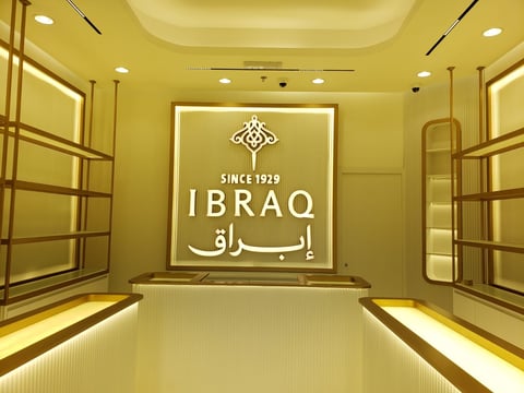 Luxury elevator interior with gold-toned walls and IBRAQ brand logo