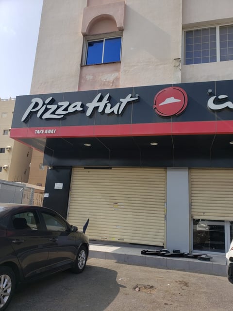 Pizza Hut take-away storefront with black and red signage