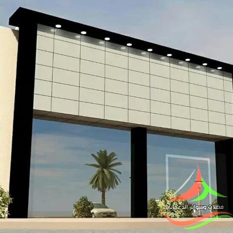 Modern building facade with large black frame, glass panels, and reflections