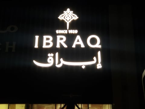 Neon sign for IBRAQ with Arabic script and decorative symbol